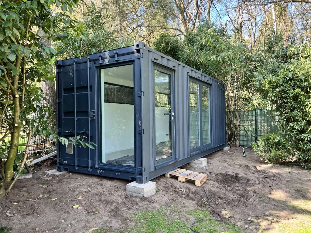 20ft high cube container home office set on concrete blocks in a garden