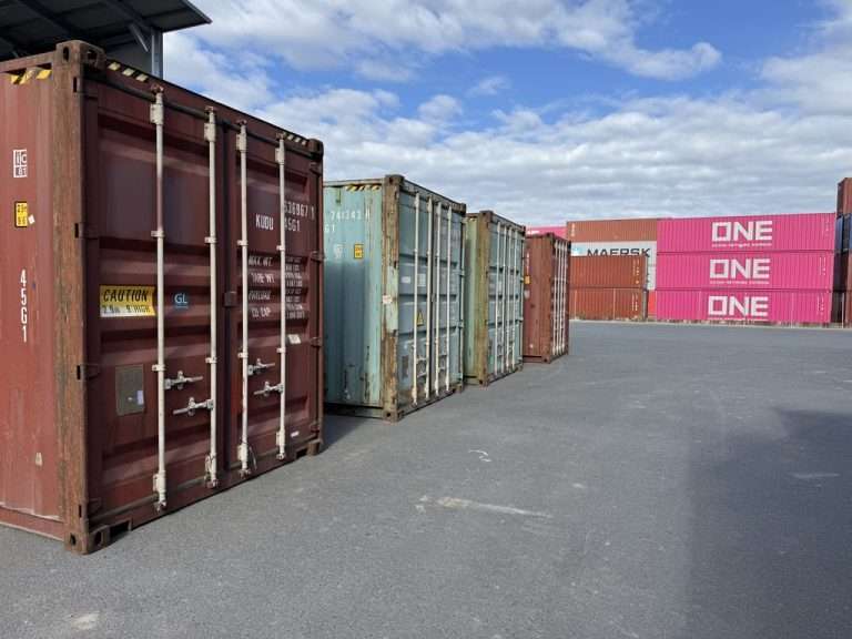 Used shipping containers at a depot, built for cargo inside, not for soil outside
