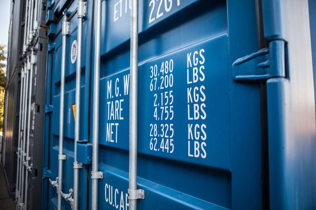 Shipping container being delivered to a US site on a tilt-bed truck