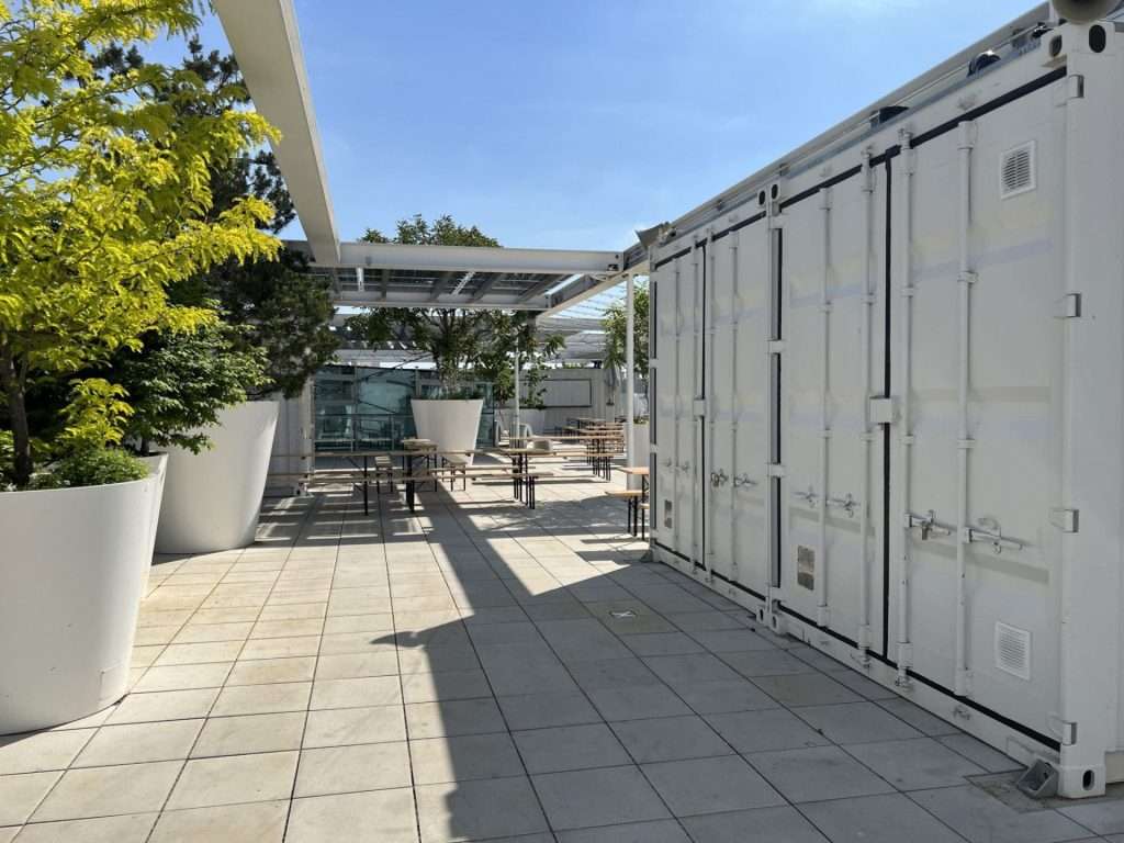 Row of converted 20ft high cube containers on a rooftop terrace