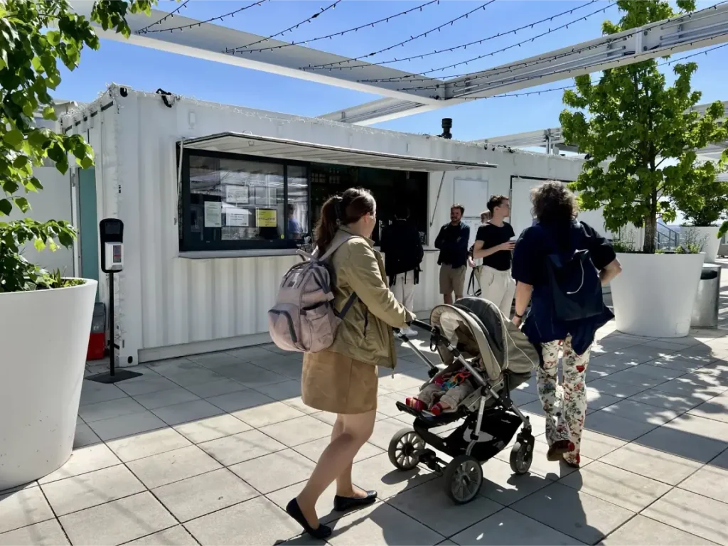 Container pop-up kiosk with customers on a rooftop terrace