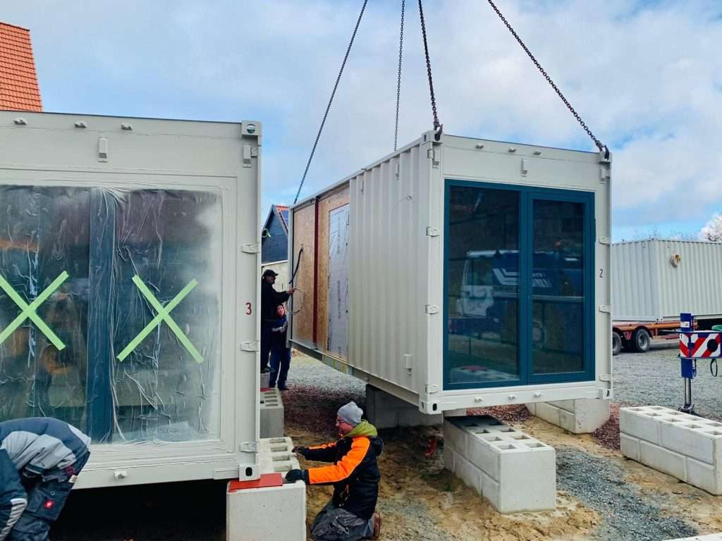 Container modules with fitted windows set on concrete block foundations