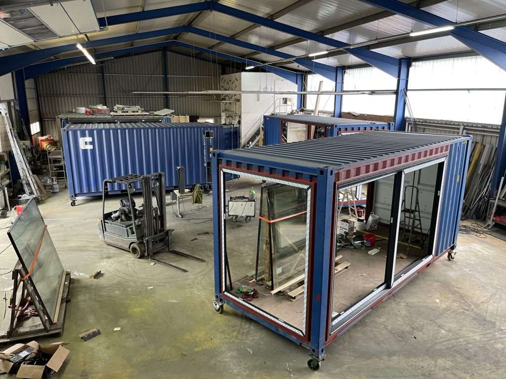 20ft shipping container in a workshop with a large window opening cut into the side wall